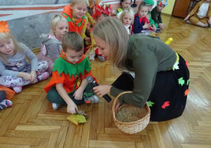 Chłopiec z Panią Jesień przelicza liście