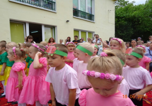 Dzieci w przebraniach do przedstawienia. Za dziećmi stoją rodzice.