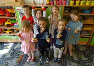 Sala przedszkolna. Dzieci pokazują jajeczka oraz zajączki wielkanocne.