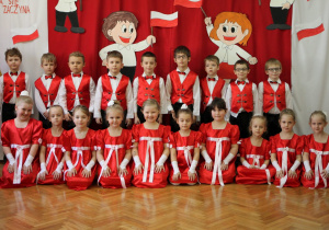Zdjęcie dzieci z gr. IV na tle biało - czerwonej dekoracji.
