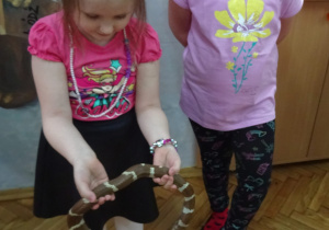 Dwie dziewczynki. Jedna z nich trzyma węża.