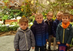 Dzieci na tle jesiennych kwiatów.