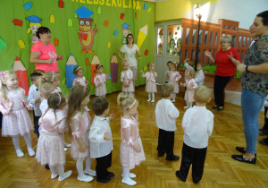 Dzieci na tle dekoracji bawią się w kole.