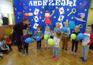 Dzieci z balonami oraz nauczycielka w stroju Czarownicy.