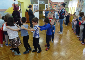 Dzieci tańczą w pociągu. 2 nauczycielki trzymają miotłę.