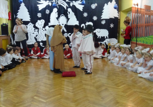 Na środku sceny dzieci odgrywające rolę Józefa, Maryji oraz pasterzy.