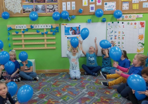 Dzieci podrzucają balony do góry.