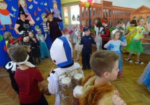 Dzieci z nauczycielkami wykonują układ taneczny.