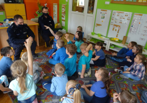 Dzieci słuchają wypowiedzi policjantów. Odpowadają na pytania.