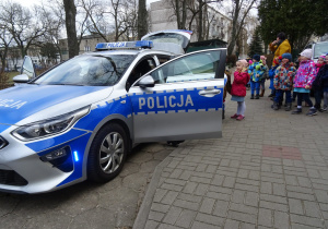 Dzieci oglądają policyjny radiowóz.