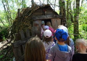 Dzieci wchodzą do drewnianego domku.