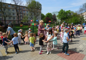 Dzieci na tarasie tańczą w parach.