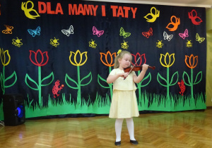 Dziewczynka gra na skrzypcach.
