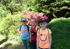 Dzieci stoją na tle roślinności.