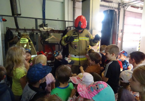Dzieci podziwiają mundur strażaka.
