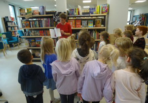 Pani Bibliotekarka prezentuje dzieciom książkę.