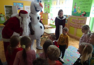 Mikołaj z Olafem i Śnieżynką odwiedza dzieci w klasie.