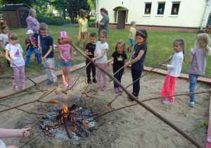 Dzieci podczas pieczenia kiełbasek.
