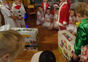 Dzieci rozpakowują prezenty.