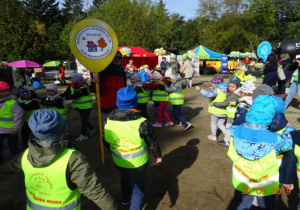 Dzieci bawią się w pociąg. Dzieci są w kamizelkach odblaskowych.