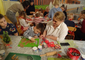 Dzieci i rodzice podczas świątecznych warsztatów kulinarnych.