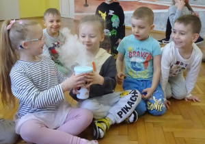 Dzieci trzymają kubek z suchym lodem.