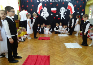 Dzieci przygotowują się do tanca z flagami.