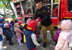 Strażak zakłada chłopcu kask.