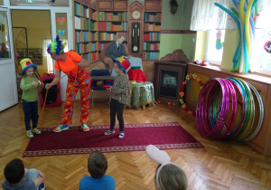 Dzieci w kapeluszach uczestniczą w pokazie cyrkowym.