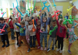 Dzieci stoją z balonami.