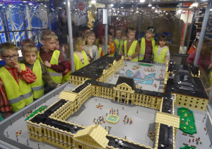 Dzieci podziwiają budowle z klocków lego.