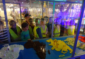 Dzieci oglądają kontynenty z klocków lego.
