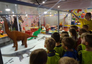 Dzieci podziwiają dinozaury z klocków lego.