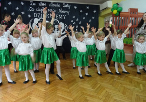 Dzieci trzymają ręce w górze.