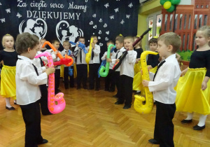 Przedszkolaki z gr. III z kolorowymi saksofonami i gitarą.