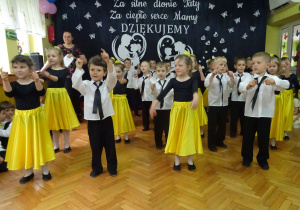 Dzieci tańczą w rzędach.