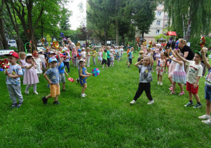 Dzieci swobodnie tańczą z wiatraczkami.
