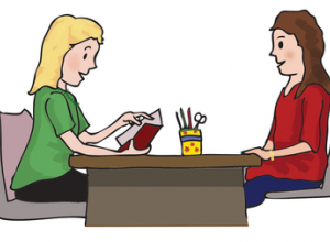 Dwie kobiety siedzące przy stole.