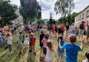 Dzieci i rodzice tańczą w kole.