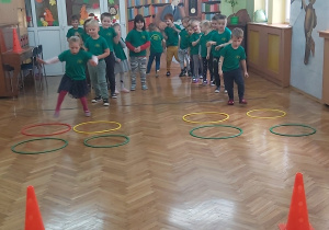 Przedszkolaki podczas zabaw sportowych z obręczami.